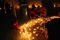 दीपावली की रात्रि में दीपक और मोमबत्ती जलाते लोग