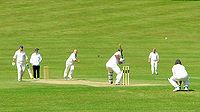 क्रिकेट के मैदान में क्रिकेट खेलते खिलाड़ी